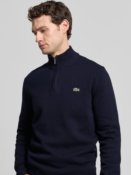 Männermodel trägt Pullover mit Logo-Patch Troyer von LACOSTE in dunkelblau, Regular Fit, Struktur-Strick, Zipper, Nahaufnahme Oberkörper.