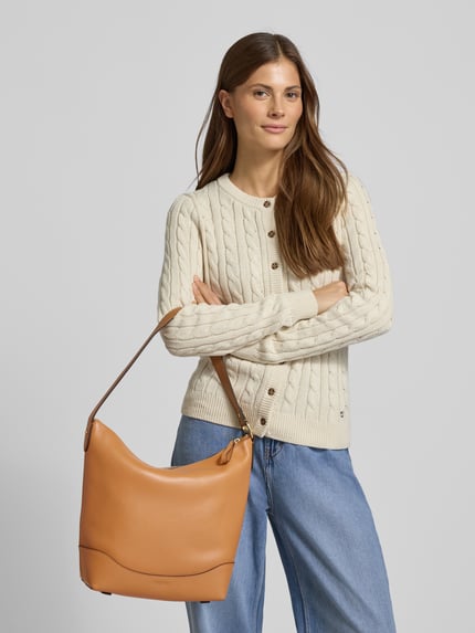 Frauenmodel trägt Lederhandtasche mit Ziernaht von Lauren Ralph Lauren aus Rindsleder, Hauptfach mit Reißverschluss, Tragehenkel; Ganzkörperansicht von vorne.