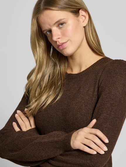 Frauenmodel trägt Strickkleid mit Label-Detail von PIECES in Dunkelbraun, grobe Stricktextur, Damen Freizeitkleid, Nahaufnahme Oberkörper.