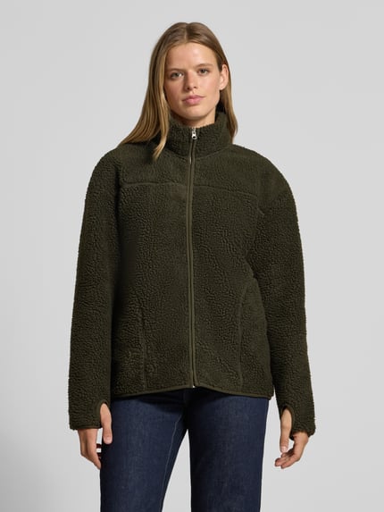 Modelka kobieca ma na sobie ciemnozieloną Relaxed Fit Teddyjacke mit Stehkragen Modell 'SAIDA' od PIECES, tekstura pluszowa, damska kurtka z materiału teddy, widok całego ciała z przodu, kontekst: damska Teddy- / Webpelzjacke od PIECES.