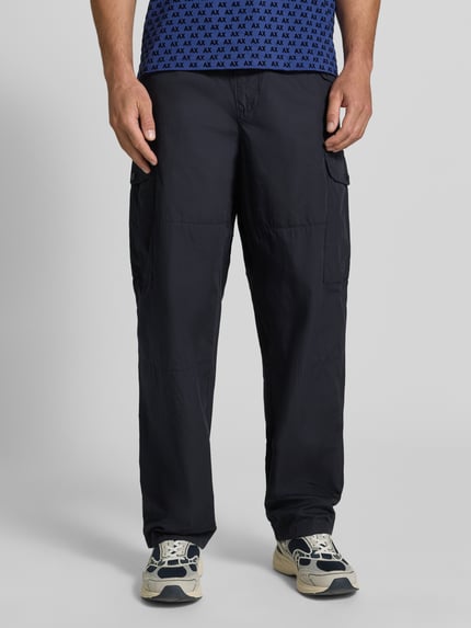 Männermodel trägt Wide Fit Cargo-Hose mit Baumwoll-Anteil von Armani Exchange in Schwarz mit elastischem Bund und Cargo-Taschen, Ganzkörperansicht von vorne.