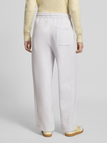 Frauenmodel trägt Sweatpants mit Baumwoll-Anteil Modell 'BAPTOWN' von American Vintage, lockere Passform, Ganzkörperansicht Rückansicht.