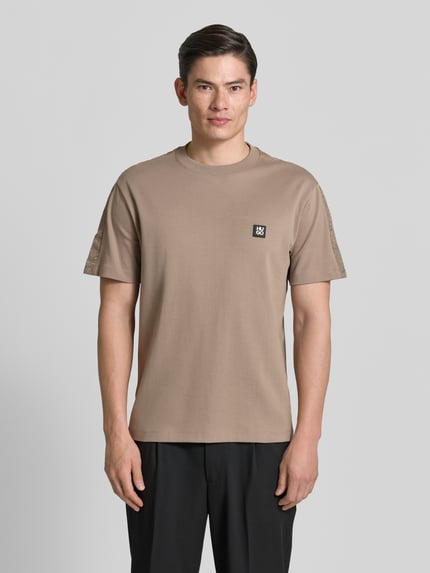 Męski model nosi Relaxed Fit T-Shirt aus reiner Baumwolle Modell 'DROSTEE' od HUGO, jednolity kolor, patch z logo, jersey, przód, ujęcie całej sylwetki z przodu.