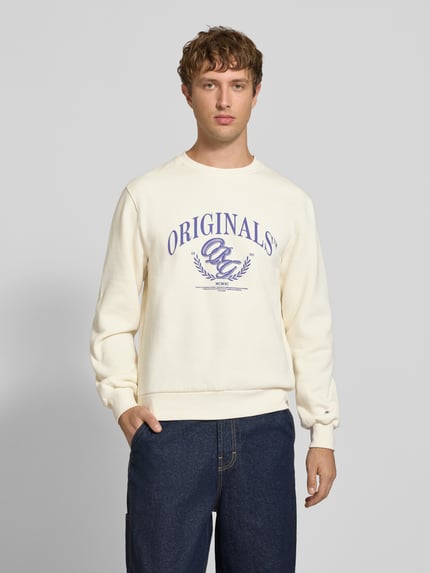 Männermodel trägt Sweatshirt mit Label-Print Modell 'FREDERIKSBERG' von JACK & JONES, cremefarben, Rundhalsausschnitt, Ganzkörperansicht von vorne, Regular Fit, Baumwoll-Mix, Rückenlänge 67 cm, Ärmellänge 68 cm.