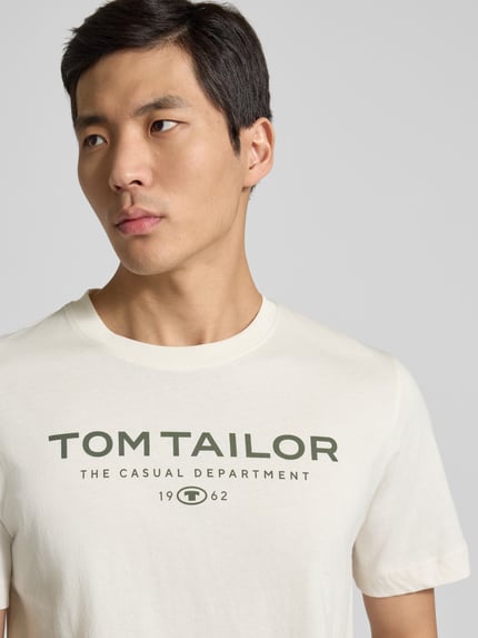 Męski model nosi Regular Fit T-Shirt aus reiner Baumwolle von Tom Tailor, efekt: jednolity kolor, nadruk z logo, okrągły dekolt, bawełna, zbliżenie na górną część ciała