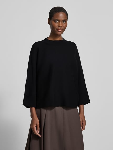 Vrouwenmodel draagt Relaxed fit gebreide pullover uit viscosemix Model 'OKTOBER' van comma, zwart met ribboorden, ruglengte maat S 55 cm, mouwlengte 38 cm, vooraanzicht buste close-up.