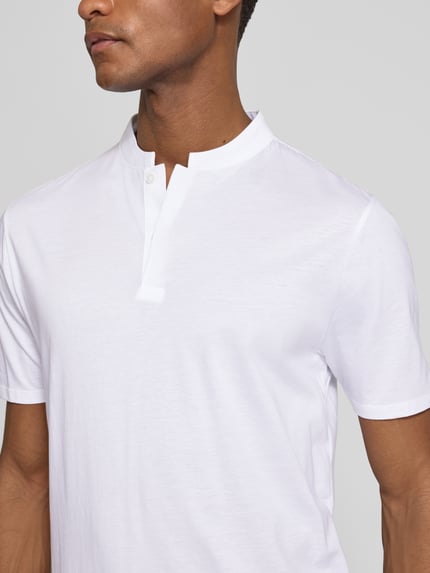 Männermodel trägt Slim Fit Poloshirt mit Stehkragen Modell 'LOUIS' von Drykorn aus Baumwoll-Modal-Mix, Nahaufnahme Oberkörper. Rückenlänge bei Größe M: 69 cm.