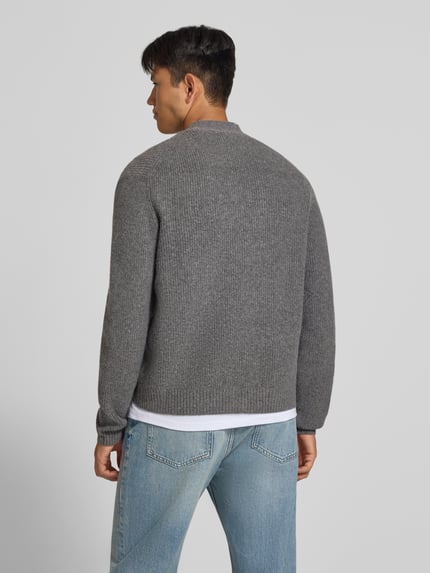 Männermodel trägt Strickjacke mit Woll-Anteil Modell 'SOUFFLE' von REVIEW in Grau, Ripp-Optik, Ganzkörperansicht Rückansicht.