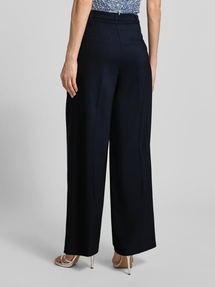 Frauenmodel trägt Wide Leg Hose mit Bindegürtel von Betty Barclay, dunkelblauer Material-Mix mit Stretch, Bügelfalten, Ganzkörperansicht Rückansicht.