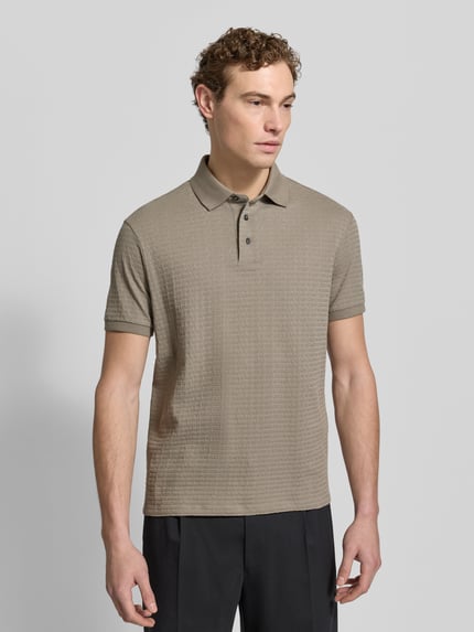 Männermodel trägt Regular Fit Poloshirt mit Strukturmuster von Emporio Armani aus reiner Baumwolle, Polokragen, Knopfleiste, Ganzkörperansicht von vorne.