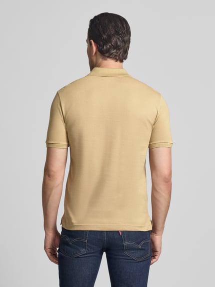 Männermodel trägt Slim Fit Poloshirt aus reiner Baumwolle von Lacoste, Optik: Unifarben, Materialverarbeitung: Piqué, Ganzkörperansicht Rückansicht.