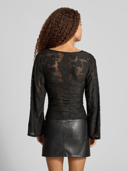 Frauenmodel trägt Langarmshirt mit Mesh Ausbrenner-Effekt von ONLY in Schwarz, Spitzendetails, ausgestellte Ärmel, Ganzkörperansicht Rückansicht.