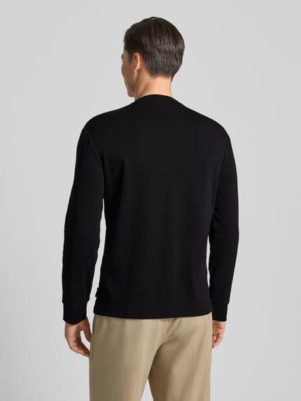 Männermodel trägt Sweatshirt mit gerippten Abschlüssen von ARMANI EXCHANGE in Schwarz, Baumwolle, Regular Fit, Ganzkörperansicht Rückansicht.