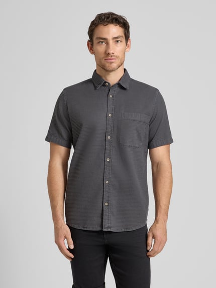Männermodel trägt Regular Fit Freizeithemd aus reiner Baumwolle von Tom Tailor in Dunkelgrau, strukturierte Optik, Kentkragen, Knopfleiste, Brusttasche, Ganzkörperansicht von vorne.