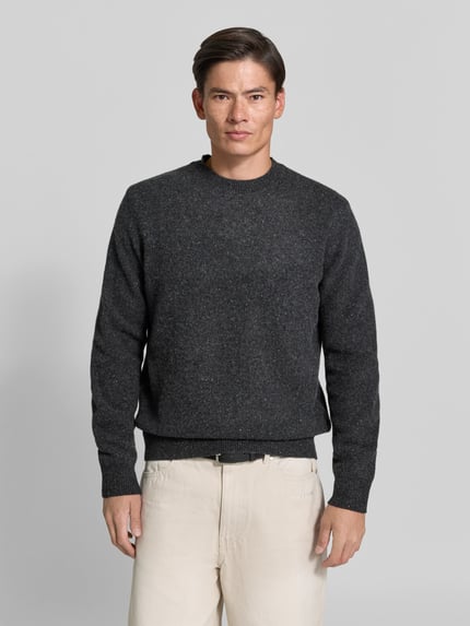 Męski model nosi sweter wełniany 'Wollpullover mi gerippten Abschlüssen' od ANNARR z wełny, luźny krój, okrągły dekolt, prążkowane wykończenia, ciemnoszary, długość tyłu w rozmiarze M: 66 cm, Ganzkörperansicht von vorne.