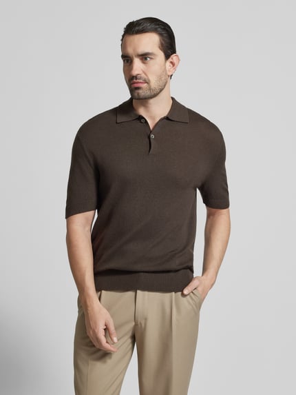 Männermodel trägt Slim Fit Poloshirt mit Kaschmir-Anteil von FTC Cashmere, braun, Baumwoll-Mix, Polokragen, Knopfleiste, 1/2-Arm, Ganzkörperansicht von vorne.