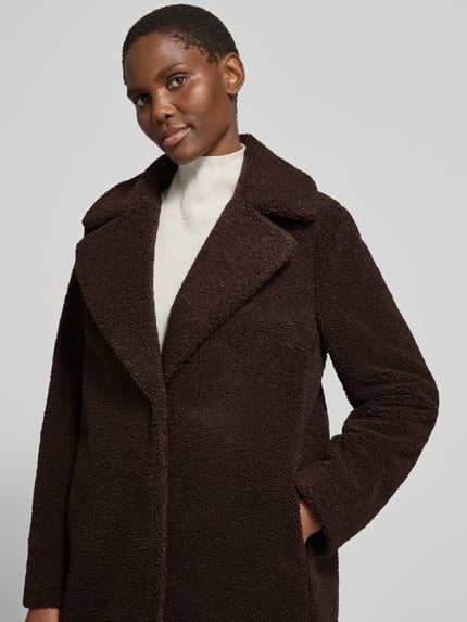 Frauenmodel trägt Teddymantel mit Reverskragen von CH. BERG WOM. SELECTION in dunkelbrauner Struktur-Optik, Nahaufnahme Oberkörper.