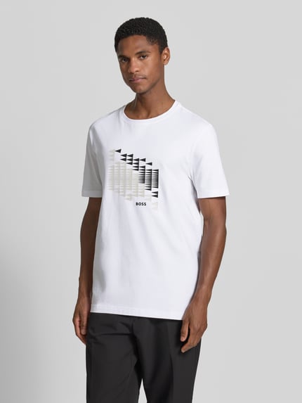 Męski model nosi Relaxed Fit T-Shirt aus Baumwoll-Mix Modell 'TS_NETWORK FLAG' od BOSS Green w bieli z czarnym nadrukiem, pełny przód.