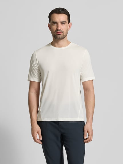 Männermodel trägt Funktionsshirt mit Rundhalsausschnitt und Logo von Salomon in Off-White, glatte Textur, Regular Fit, Ganzkörperansicht von vorne.