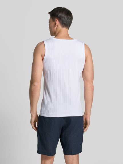 Mężczyzna nosi Regular Fit Tank Top aus Baumwoll-Mix Modell 'ANDRE' od SELECTED HOME, biała, prążkowana struktura, okrągły dekolt, szerokie ramiączka, dzianina typu feinripp, z mieszanki bawełny, widok całej sylwetki z tyłu.