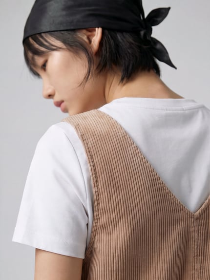 Frauenmodel trägt Minikleid aus Cord mit aufgesetzten Taschen von MOP DENIM in Beige, V-Ausschnitt, unifarben, Nahaufnahme Oberkörper.