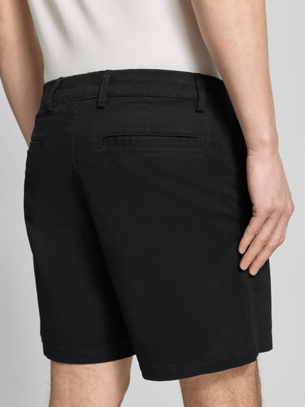 Männermodel trägt Shorts mit französischen Eingrifftaschen von GAP, Baumwoll-Mix, schwarz, Straight Fit, Ganzkörperansicht Rückansicht.