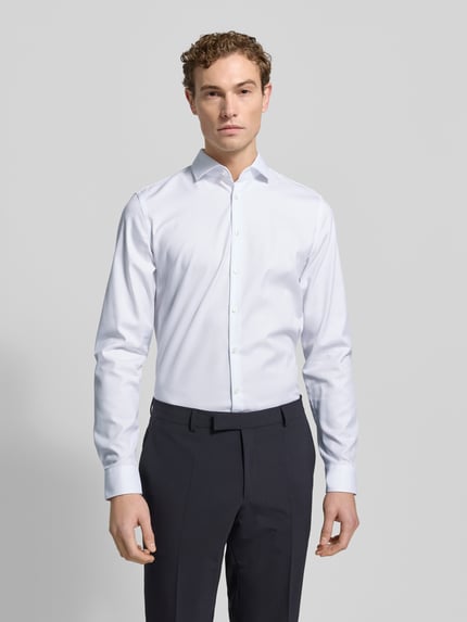 Männermodel trägt Slim Fit Businesshemd mit extra langem Arm von Jake*s, reine Baumwolle, Kentkragen, Knopfleiste, Ganzkörperansicht von vorne.