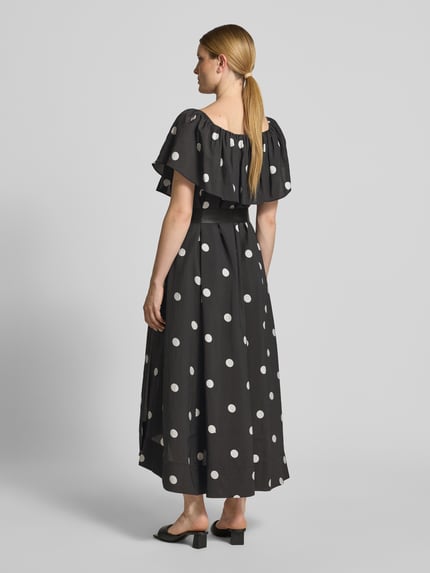 Frauenmodel trägt Midikleid mit Gürtel und Carmen-Ausschnitt Modell 'FIE' von Copenhagen Muse, schwarz mit weißen Punkten, Lyocell-Mix, taillierter Schnitt, Rückansicht Ganzkörperansicht.