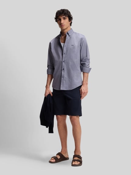 Männermodel trägt Regular Fit Freizeithemd aus Oxford-Baumwolle Modell 'RICKERT' von BOSS Orange in Melange-Optik, Ganzkörperansicht von vorne.