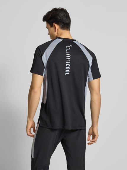 Mężczyzna nosi Męski t-shirt z nadrukiem z logo T-Shirt mit Label-Print od adidas Training, krój regular fit, prążkowany okrągły dekolt, długość tyłu 72 cm dla rozmiaru M, widok całej sylwetki od tyłu.