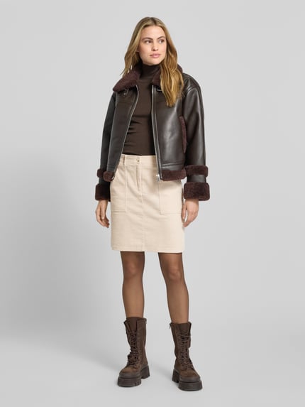 Vrouwenmodel draagt Minirok met steekzakken model 'Reah' van OPUS, beige katoen, relaxte pasvorm, voorkant volledig zichtbaar, geheel lichaamsaanzicht.