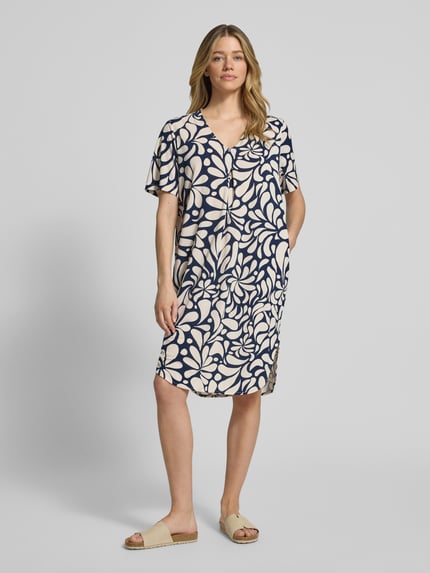 Modelka kobieca nosi Knielanges Kleid mit V-Ausschnitt Modell 'Floy' od FREE/QUENT, beżowo-granatowy wzór, materiał z dodatkiem stretchu, krój straight fit, długość do kolan, widok całej sylwetki z przodu.
