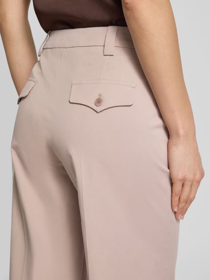 Frauenmodel trägt Slim Fit Hose mit Bügelfalten von Windsor aus Baumwoll-Elasthan-Mix in Beige mit Gesäßtaschen, Nahaufnahme Rückansicht.