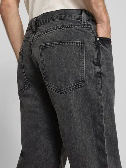 Männermodel trägt Baggy Jeans in Grau im klassischen 5-Pocket-Look von REVIEW, reine Baumwolle, lockere Passform, Detailaufnahme Rückansicht.