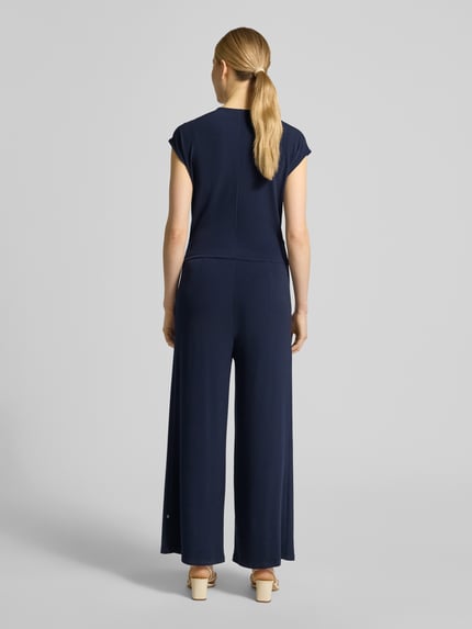 Frauenmodel trägt Jumpsuit in Wickel-Optik mit V-Ausschnitt von ROBE LÉGÈRE in Dunkelblau, Material-Mix mit Stretch-Anteil, Regular-Fit, Ganzkörperansicht Rückansicht. Rückenlänge 49 cm, Brustweite 42 cm, Gesamtlänge 147 cm, Innenbeinlänge 63 cm bei Größe 36.