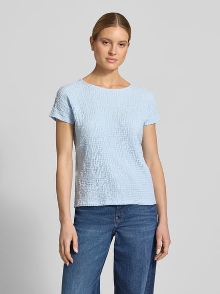 Vrouwenmodel draagt Relaxed Fit T-shirt met structuurpatroon van s.Oliver RED LABEL in lichtblauw, kreuklook, ronde hals, korte mouw, look: effen, relaxed fit pasvorm, materiaalverwerking: kreuk, geheellichaamsaanzicht van voren.