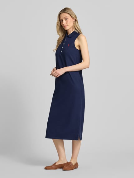 Frauenmodel trägt Figurumschmeichelndes Polokleid aus Baumwoll-Mix von Polo Ralph Lauren in Optik: Unifarben, Midi-Länge, Piqué-Struktur, Logo-Stitching, Seitenschlitz, Ganzkörperansicht von vorne.
