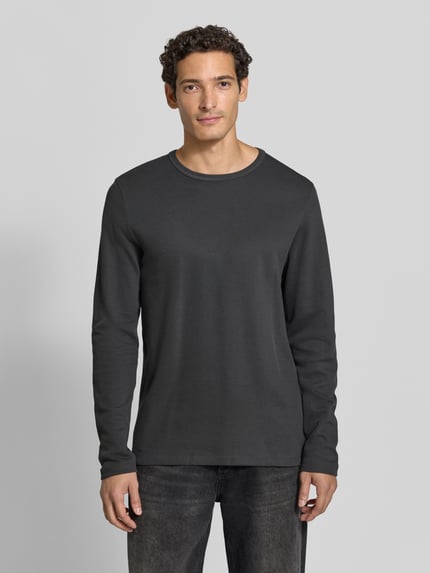 Männermodel trägt Regular Fit Longsleeve aus reiner Baumwolle Modell 'Basic' von Lindbergh in Dunkelgrau mit Rundhalsausschnitt, Ganzkörperansicht von vorne. Herren Longsleeve, Rückenlänge bei Größe M: 73 cm.