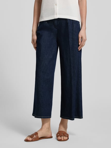 Frauenmodel trägt Wide Fit Jeans mit Lyocell-Anteil Modell 'Jenny' von TONI aus dunklem Denim mit Bundfalten, Eingrifftaschen, Gesäßtaschen, Knopf-Reißverschluss, elastischem Baumwoll-Lyocell-Mix, Ganzkörperansicht von vorne.