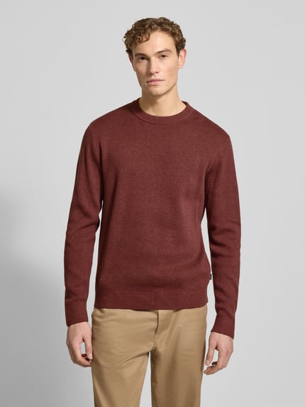 Męski model prezentuje Strickpullover mit gerippten Abschlüssen Modell 'BLAMILANO' od Jack & Jones Premium, bawełna, regular fit, kolor bordowy, okrągły dekolt, pełny przód, zdjęcie całej sylwetki z przodu.