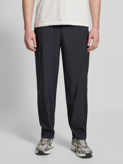 Männermodel trägt Hose mit elastischem Bund und Gesäßtaschen von ARMANI EXCHANGE, Relaxed-Fit, schwarzer Material-Mix, Ganzkörperansicht von vorne.