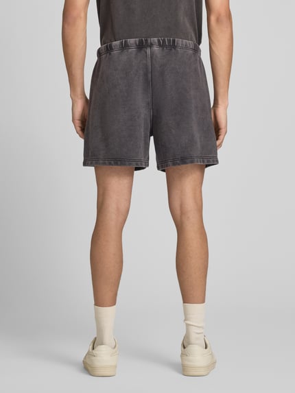 Männermodel trägt Sweatshorts mit Eingrifftaschen von CHAMPION in Anthrazit, Baumwoll-Mix, Regular Fit, Ganzkörperansicht Rückansicht.