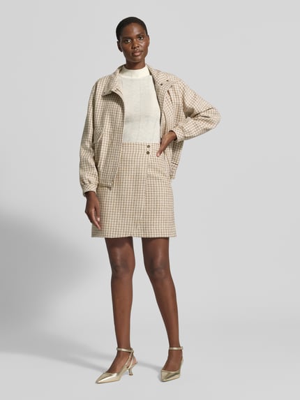 Frauenmodel trägt Strickpullover aus Schurwolle-Mix mit Stehkragen von Marc Cain in Creme, Slim Fit, feine Textur, Ganzkörperansicht von vorne. Rückenlänge 55 cm, Ärmellänge 66 cm, Kaschmir-Anteil, Label-Detail.