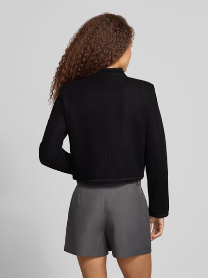 Frauenmodel trägt schwarzen Blouson mit Uniform Zierknöpfen Modell 'ONLNANCY' von ONLY, unifarben, cropped, Rückansicht