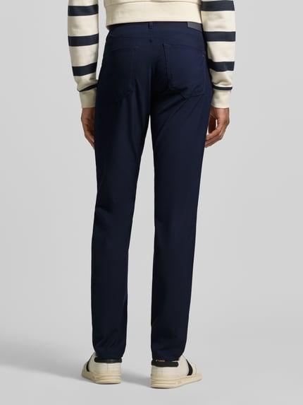 Męski model nosi Hose mit Eingrifftaschen Modell 'Chuck' od Brax, granatowy, krój regular fit, materiał z domieszką wiskozy, szerokość w rozmiarze 32/32: 43 cm, długość wewnętrzna nogawki: 84 cm, widok całej sylwetki z tyłu.