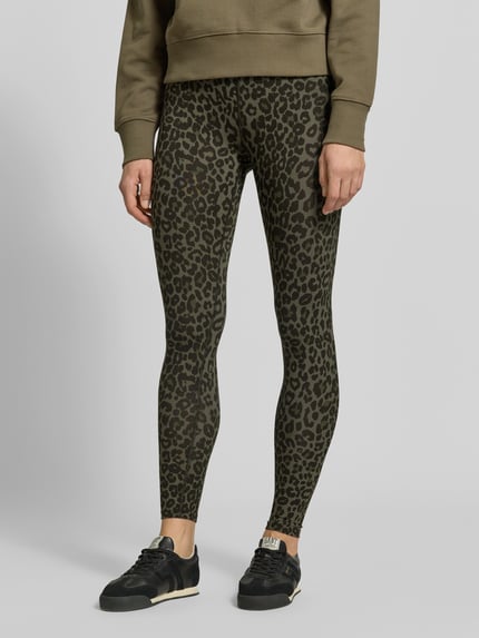 Frauenmodel trägt Leggings aus Viskose-Mix von Lala Berlin mit Leopardenmuster in Khaki, eng anliegend, High Waist, Knöchellänge, Nahaufnahme Unterkörper.