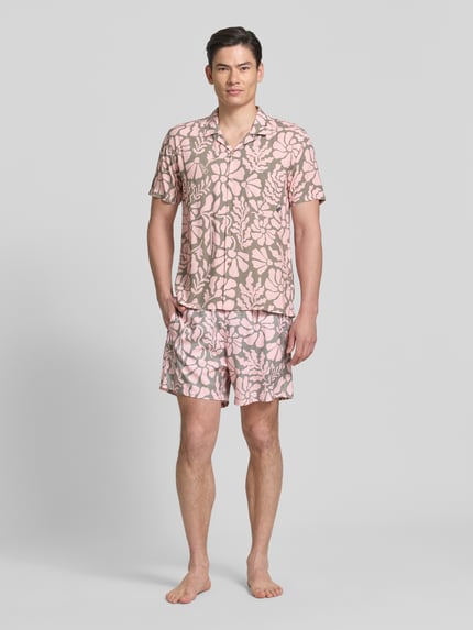 Männermodel trägt Freizeithemd im Allover-Look Modell 'Melo' von BOARDIES, rosa-beige, florales Muster, Regular Fit, Ganzkörperansicht von vorne. Produkt aus reinen LENZING™ ECOVERO™ Fasern mit Reverskragen, Brusttasche, kurzer Ärmel.
