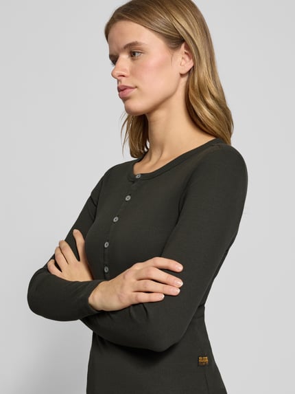 Frauenmodel trägt Slim Fit Longsleeve mit Rundhalsausschnitt und Knopfleiste von G-Star Raw in Dunkelgrün, Baumwoll-Elasthan-Mix, Nahaufnahme Oberkörper.