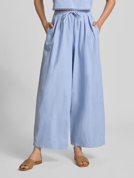 Frauenmodel trägt Stoffhose mit elastischem Bund und Tunnelzug Modell 'FEOLY' von American Vintage in Hellblau, Baumwolle, Wide Leg, Nahaufnahme Unterkörper, Kontext: Damen Stoffhose, Bundweite S 34 cm, Innenbeinlänge S 71 cm.