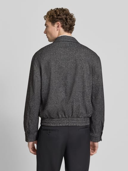 Männermodel trägt Regular Fit Blouson mit Viskose-Anteil von MCNEAL in antraciet met fijne textuur, platte kraag, tweewegritssluiting, Ruglengte maat M: 65 cm, Schouderbreedte: 63 cm, Borstwijdte: 61 cm, Mouwlengte: 64 cm, Ganzkörperansicht Rückansicht.